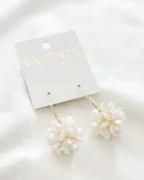 Aros colgantes con forma de flor, hechos con cuentas facetadas color crema.