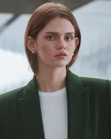 Aros pequeños de bronce con forma irregular y acabado liso, estilo huggie o argolla gruesa.