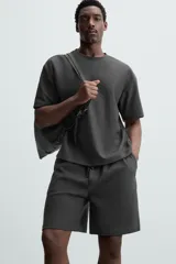Bermuda negra de corte relaxed fit, con cintura elástica ajustable con cordón, bolsillos frontales y bolsillo trasero de parche.