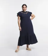 Vestido midi azul marino de media malla de algodón, con bordado Richelieu en el busto, mangas cortas con volados y bajo fruncido con volado.
