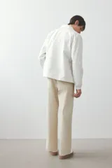 Pantalón color beige de popelina de algodón, corte ancho, con cintura elástica ajustable con cordón, bolsillos laterales y traseros.