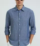 Camisa celeste de lino con cuello camisero, abotonadura frontal y mangas largas.