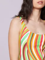 Tankini de dos piezas, musculosa con estampado de círculos negros y verdes sobre fondo blanco, con escote cuadrado, copa armada y sujetador interno. Incluye bombacha negra lisa.