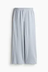 Pantalón de felpa celeste, de corte relajado con cintura elástica fruncida, bolsillos laterales discretos y piernas rectas.