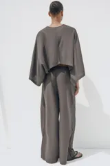 Pantalón blanco de lino, de corte ancho y tiro medio, con cintura elástica ajustable con cordones y bolsillos laterales.