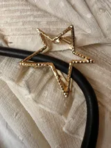 Pinza dorada para el pelo con forma de estrella.