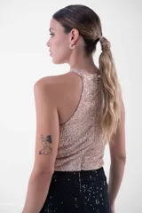 Vestido largo de fiesta con cuello halter y lentejuelas color verde esmeralda en el top y negro en la falda.