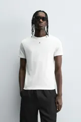 Camiseta negra de corte slim fit, cuello redondo y manga corta. Confeccionada en tejido de algodón con elasticidad y acabados en rib.