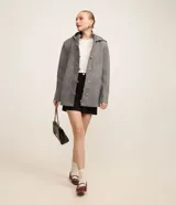 Saco gris de polivelour con capucha, cuello alto con cremallera, abotonado delantero cruzado, bolsillos delanteros y mangas largas.