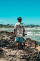 Remerón de manga corta, color crudo con efecto tie-dye o lavado en tonos azules y beige. Presenta un estampado frontal con olas y el texto "GLASY WAVES".