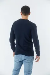 Sweater negro de algodón con cuello redondo y logo bordado en el pecho.