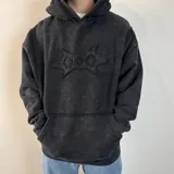 Canguro negro con capucha, corte oversize y estampa abstracta en el pecho.