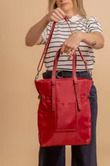 Cartera tipo tote bag color negro, con doble asa de mano y correa bandolera ajustable. Presenta un bolsillo rectangular en el frente.