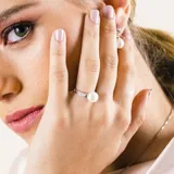 Anillo de plata 925 con perla de río y circonias engarzadas en la alianza.