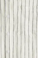 Camisa de lino color blanco con rayas verticales negras, cuello clásico, cierre frontal con botones, manga larga con puños abotonados, bolsillo de parche en el pecho y bajo redondeado.