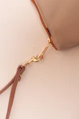 Sobre de algodón a rayas verticales de colores naranja, rosa, marrón, rojo y blanco. Tiene cierre superior con cremallera y tira de cuero marrón para la muñeca.