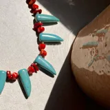 Collar con cuentas de piedra turquesa y coral rojo.