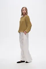 Pantalón de lino color blanco, de corte ancho y tiro alto, con bolsillos laterales y pinzas.