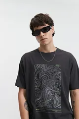 Remera lila de manga corta con cuello redondo y estampado de mapa topográfico en el frente.