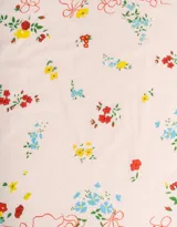 Pañuelo cuadrado de algodón color blanco con estampado de flores rojas, azules y amarillas, y ribete ondulado rojo.
