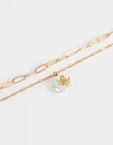 Collar corto dorado de doble cadena, una de eslabones grandes y otra de eslabones finos, con dije de perla irregular y ángel dorado.