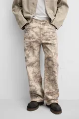 Pantalón de jean de corte recto con estampado abstracto en tonos beige, marrón y gris.