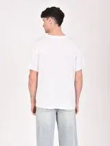 Remera color crudo con estampa frontal de estilo western con texto y paisaje desértico.