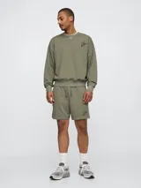 Short deportivo color verde oliva, con cintura elástica ajustable con cordón y logo de la marca bordado en negro.