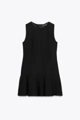 Vestido corto negro sin mangas, con cuello redondo y falda con tablas. Cierre trasero con cremallera oculta.