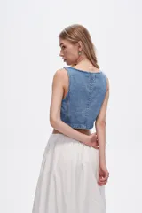 Chaleco crop top de jean celeste con botones frontales.