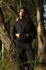 Conjunto deportivo negro compuesto por un hoodie con capucha y bolsillo canguro, y un pantalón jogging con bolsillos laterales y cintura ajustable con cordón.