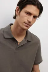 Remera polo color marrón de piqué de algodón, de corte regular fit, con cuello clásico, tapeta de botones, mangas cortas y bajo recto con aberturas laterales.