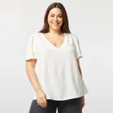 Blusa blanca de textura arrugada, con escote en V y mangas cortas abullonadas.