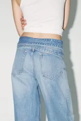 Pantalón de jean celeste de tiro alto, corte wide leg y largo hasta el tobillo. Incluye cinturón de la misma tela con trabillas y cierre frontal con cremallera, botón y gancho metálico.