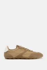 Zapatillas deportivas color beige, de estilo running, con puntera redonda y suela dentada.