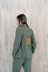 Blazer verde con rayas verticales blancas, solapas clásicas y corte entallado.