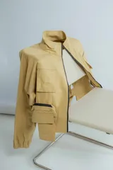 Campera de corte a la cintura color tostado, con diseño de bolsillos y puños elásticos.