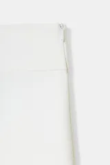 Pantalón blanco de tiro alto y pierna ancha, con cierre lateral oculto.