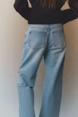 Pantalón de jean celeste de corte acampanado, tiro alto y cinco bolsillos.
