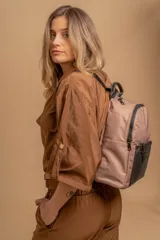 Mochila urbana color gris con detalles en cuero sintético negro. Cuenta con un compartimento principal amplio y un bolsillo frontal con cierre.