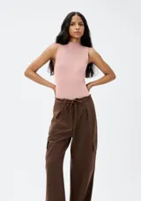 Musculosa rosa de tejido acanalado con cuello alto.