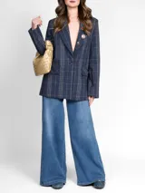 Blazer azul a cuadros con cierre frontal de un solo botón, solapa en el escote con aplique decorativo y dos bolsillos delanteros con solapa.