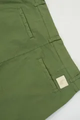 Pantalón verde oliva de algodón con textura seersucker, bolsillos laterales y traseros, cierre con botón y cremallera, parche con logo.