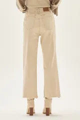 Jean de tiro alto y pierna ancha, color beige claro, con terminación deshilachada en el ruedo.