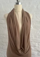 Vestido corto color beige, con escote halter y espalda descubierta. Ajustado al cuerpo y confeccionado en microtul.