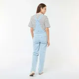 Enterito de jean celeste claro, estilo peto o jardinero, con panel elástico para maternidad sobre el abdomen. El corte de las piernas es recto y holgado.