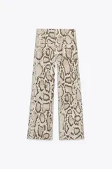 Pantalón semitransparente de tiro medio con cintura elástica ajustable con cordones, bolsillos laterales y pierna recta.