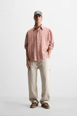 Pantalón color marrón con efecto lavado, corte relaxed fit, cinco bolsillos, aplicación de tira y bolsillo multifunción en perneras, cierre frontal con cremallera y botón.
