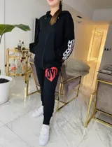 Pantalón de jogging negro de algodón con cintura ajustable y estampado de un corazón rojo con la palabra "LOVE" en una pierna.