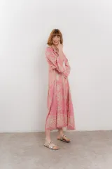 Vestido largo azul con estampado floral en tonos beige, confeccionado en viscosa. Presenta escote en V, botonadura completa en el frente y mangas largas con volados.